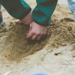 garcon jouant avec du sable
